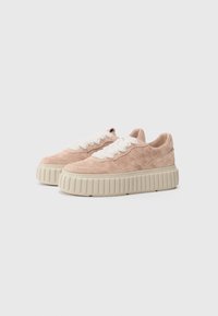 Chunky platform sneakers in soft pink suede with a textured beige rubber sole. Features thick white laces and stitching details on the upper.