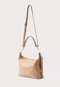 Tanfarvet læderhåndtaske med guldfarvet hardware, justerbar skulderrem og glat tekstur. Har en toplynlås og minimalistisk design.