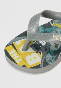 Sive gumenjaci s uzorkom na ulošku koji prikazuje Batman dizajn u strip stilu na žutoj i crnoj pozadini. Tekst glasi "BATMAN".