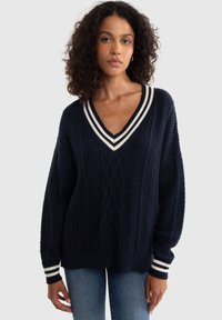 Maglione lavorato a maglia blu navy con scollo a V, caratterizzato da righe bianche sul colletto e sui polsini, un motivo testurizzato e una vestibilità comoda.