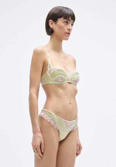 Lime zöld fehérnem�ű szett, amely egy csipkés szegéllyel díszített balconette melltartóból és csipke részletekkel ellátott, hozzáillő bugyiból áll, sima szatén anyagból készült.