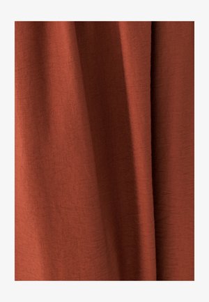 Tkanina v rustikálnej farbe s mäkkými záhybmi a jemným textúrovaným tkaním, vytvárajúca teplý a prírodný vzhľad.