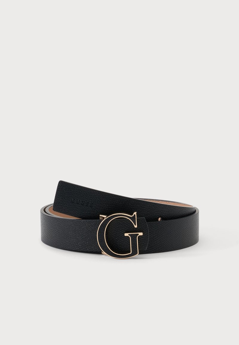Ceinture en cuir noir enroulée avec une boucle en métal doré en forme d'une grosse lettre G sur un fond clair uni.