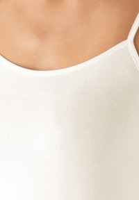 White, ribbed tank top with thin straps, featuring a soft texture and a scoop neckline. No visible patterns or embellishments.