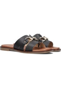 Zwarte leren slidesandalen met twee brede banden, voorzien van een gouden decoratieve kettingaccent. Bruine zool en een gladde textuur.