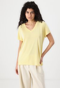 V-neck yellow t-shirt made of soft fabric with short sleeves. The shirt has a relaxed fit and subtle striped texture.