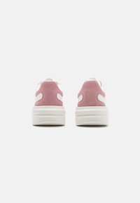 Sneaker bianche e rosa chiaro con una finitura in pelle liscia e scamosciata, dotate di una suola spessa e un design con il retro arrotondato.