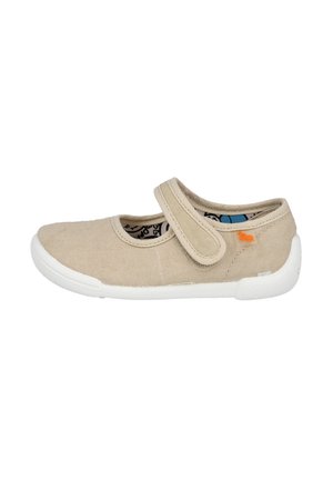 Zapato de lona beige con una tira de velcro, suela de goma blanca, puntera redondeada y un pequeño acento naranja en el lateral. Acabado de tejido texturizado.