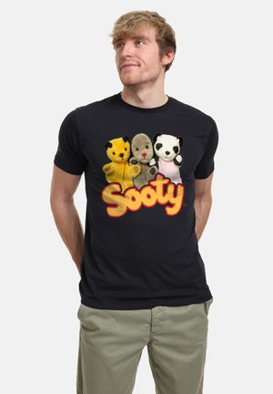Sort bomulds T-shirt med fire plysdyr karakterer og teksten "Sooty" i fed, gul-orange skrift. Korte ærmer og rund halsudskæring.