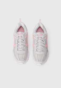 Une paire de chaussures de course Nike blanches et rose clair avec des tiges en mesh et synthétique, vues de dessus sur un fond blanc uni.