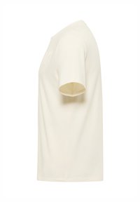 T-shirt z okrągłym dekoltem i krótkimi rękawami w kolorze kremowym, wykonany z bawełny, o prostym kroju i subtelnej fakturze. Charakteryzuje się minimalistycznym wzornictwem bez widocznych logo.