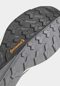 Gummisohle mit tiefem, aggressivem Profil. Merkmale eine dunkelgraue Basis mit schwarzen Akzenten und dem orangen "Continental"-Logo für verbesserten Halt.