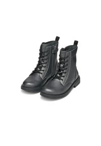 Botas de tobillo de cuero negro con cierre de cordones, cremallera lateral y suela de goma. Presentan costuras en contraste y una tira en el collar.