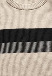 Maglione lavorato a maglia di colore crema con una larga striscia orizzontale nera e una texture a coste. Presenta un collo rotondo e dettagli in grigio. 