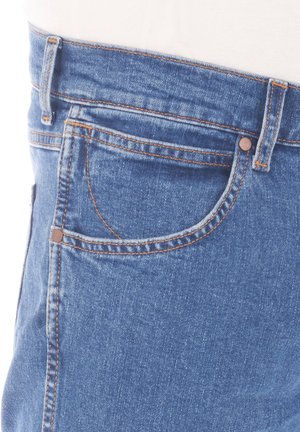 Jeans van denim in mid-blauw met contrasterende oranje stiksels. Kenmerken zijn onder andere een vijf-pocket ontwerp en ceintuurlussen in de tailleband.