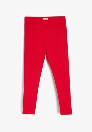 Czerwone legginsy o kroju dopasowanym, z elastycznym pasem, dwoma bocznymi kieszeniami i gładką, matową fakturą. Zaprojektowane z myślą o ścisłym dopasowaniu.