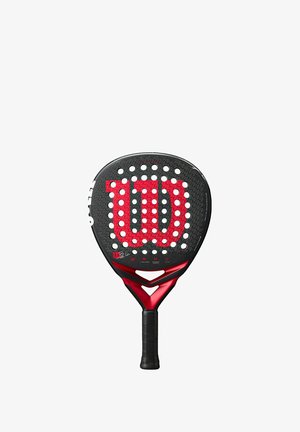 Wilson padelracket med svart yta och röda accenter, cirkulära perforeringar och strukturerat grepphandtag. Designad för hållbarhet och prestanda.