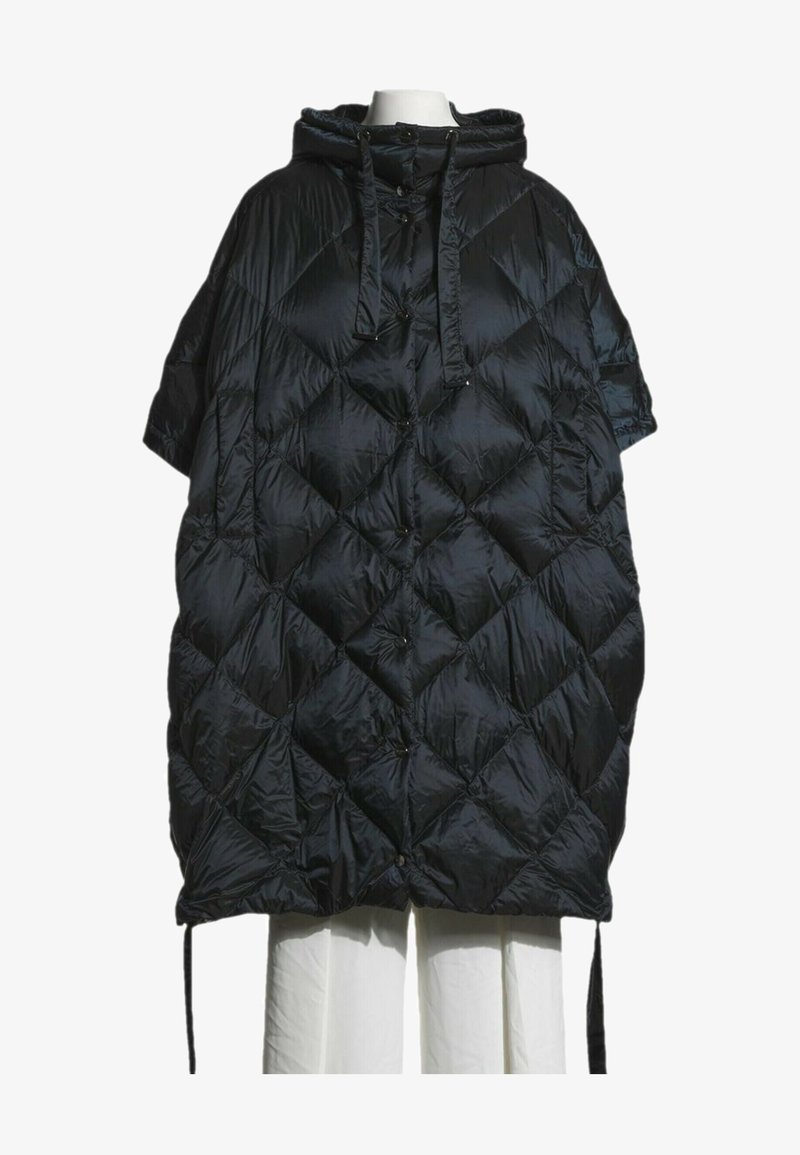Doudoune noire matelassée oversize avec capuche, manches courtes et cordons, portée sur un mannequin sans tête vêtu d'un pantalon blanc.