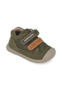 Chaussure en suède verte avec une sangle en Velcro marron, bout rond, détails cousus et semelle en caoutchouc. Idéale pour le confort et le soutien.