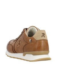 Sneaker en cuir marron avec une texture lisse et des accents beiges contrastants. Il possède une semelle blanche et un logo sur le côté et le talon.