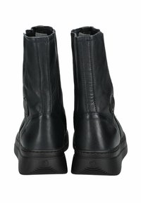 Botas de tobillo negras de cuero con una textura lisa, punta redondeada y detalle de botón lateral, que cuentan con una suela de goma para mayor tracción.