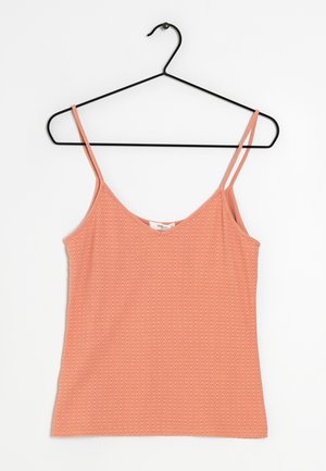Débardeur rose texturé à bretelles spaghetti suspendu sur un cintre métallique noir sur fond blanc.
