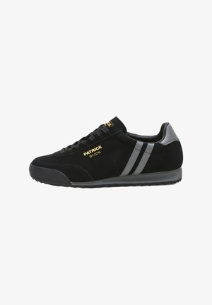 Schwarze Wildleder-Sneaker mit strukturiertem Obermaterial, grauen Streifen und goldener Markenprägung. Gummisohle mit klassischer sportlicher Form.