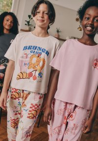 Koszulki z krótkim rękawem z nadrukami i wzorzyste spodnie piżamowe w jasnych kolorach. Z motywami związanymi z jedzeniem i zabawnymi ilustracjami.