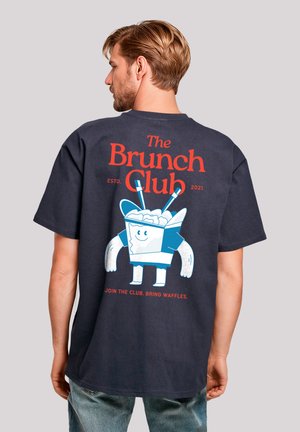 Navy cotton t-shirt featuring a large graphic print of a smiling food container character, with red and blue text on the back. Short sleeves.
