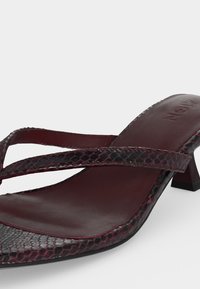 Σκούρο κόκκινο πέδιλο με τετράγωνη μύτη, λεπτά υφασμένα λουράκια και χαμηλό κωνικό τακούνι.