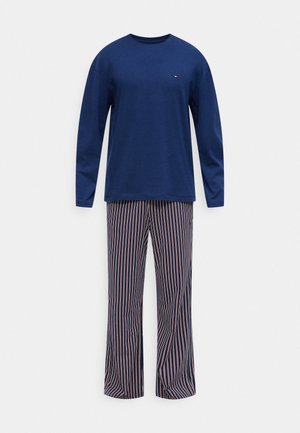 Tumesinise värviga pikkade varrukatega särk ja sobivad püksid, millel on vertikaalsed punased ja valged triibud. Puuvillane materjal, kerge ja lõdvestunud lõige, ümar kaelus ning pehme tekstuur.