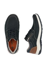 Chaussures en suède bleu foncé avec couture blanche, un accent en cuir marron et une fermeture éclair sur le côté. Semelle en caoutchouc avec une texture antidérapante.