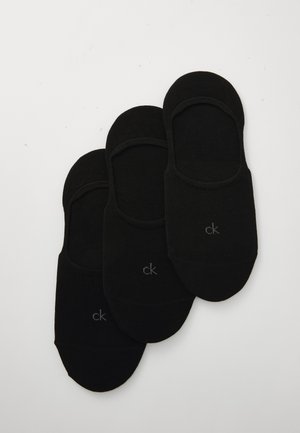 Mustad musta puuvillased sokid, mis ei paista kingadest välja, siledast tekstuurist, küljes väike hall "ck" logo, virnastatud kergelt kattuvatesse kuhjadesse.