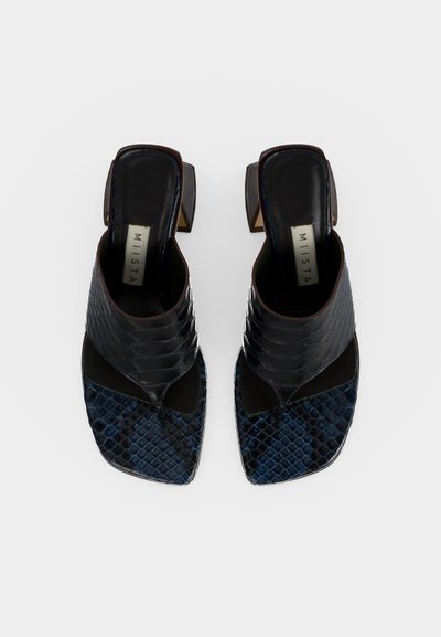 Ζευγάρι μαύρα και σκουρομπλε πέδιλα με τακούνι, σχέδιο φολιδωτής όψης φίδι και τετράγωνες μύτες με φαρδιές μπροστινές λουριά, από πάνω.