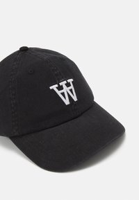 Juodas medvilnės beisbolo kepuraitė su balta siuvinėta "W" logotipu. Ypatybėmis: kreivėnė skydelis ir reguliuojama nugarinė juosta. Tekstūruotas paviršius.