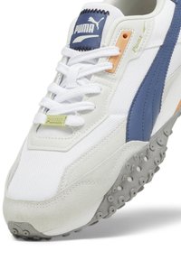 Weiße Sneaker mit blauen Lederakzenten und einer strukturierten grauen Gummisohle. Ausgestattet mit gebrandeter Zunge, flachen Schnürsenkeln und einer Mischung aus Mesh- und Wildledermaterialien.