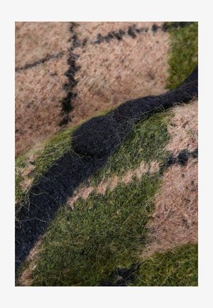 Gyapjú textília kockás mintával, zöld, rózsaszín és fekete színekkel. A textúra puha és bolyhos, jól látható rostokkal.