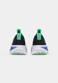 Scarpe da ginnastica nere con accenti verdi, una suola bianca ammortizzata e superiore in rete. Presentano una linguetta sul tallone per indossarle facilmente.