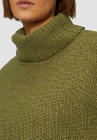 Olijfgroen gebreid trui met een hoge, geribbelde col. De textuur is zacht met een subtiel patroon, wat zorgt voor een gezellige en comfortabele uitstraling.