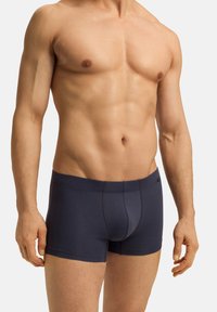Pánské boxerky v námořnické modré barvě, vyrobené z jemné látky, s přiléhavým střihem, kontrastním prošíváním a elastickým pasem.