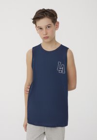 Maglietta senza maniche blu navy in cotone, con una piccola grafica bianca "LA" sul petto. Design semplice e dritto senza decorazioni.