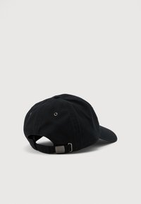 Svart justerbar baseballcaps med metallspenne og ventilasjonsluker, vist fra baksiden på en enkel lys grå bakgrunn.