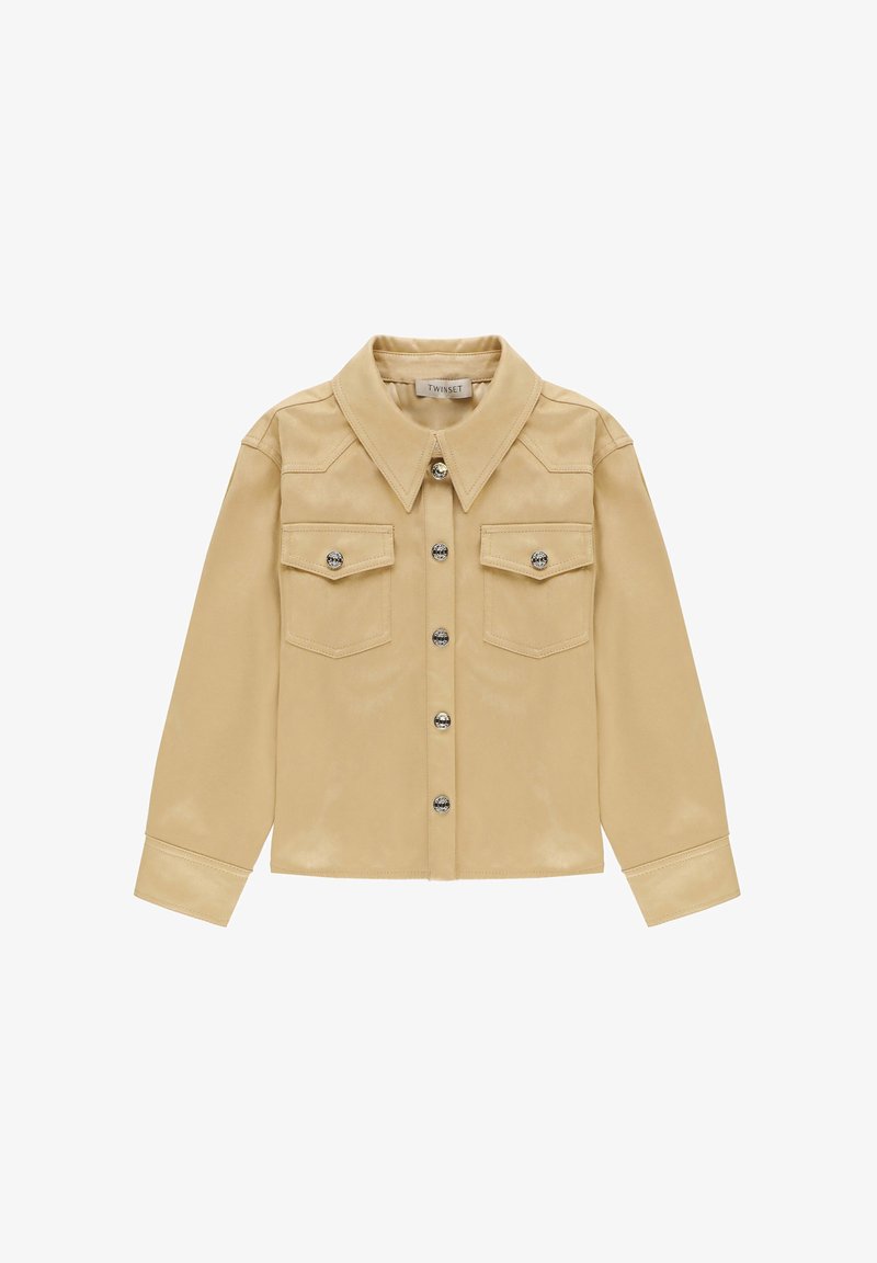 Beige langærmet skjorte med knapper, spids krave, to frontlommer med klapper og knapper, samt sølvfarvede knapper ned ad midten.