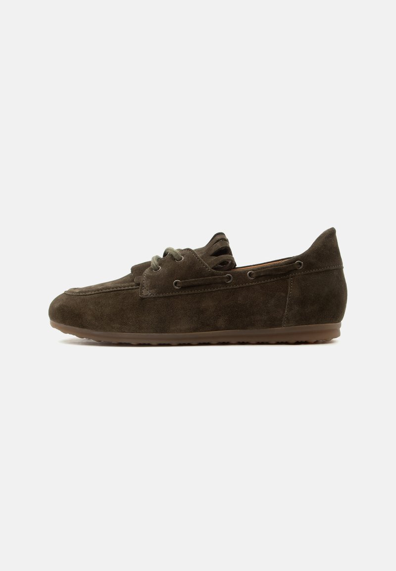 Mocassin en daim brun foncé avec détail en lacet et semelle en caoutchouc, présenté de côté sur un fond clair uni.