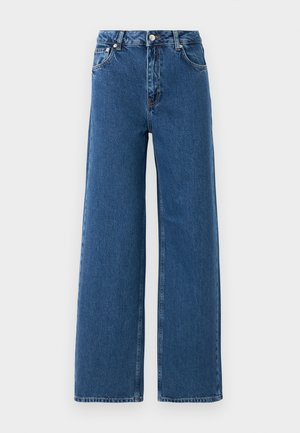 Jeans de cintura alta e pernas largas, de cor azul, com fecho frontal por botão e zip, bolsos frontais e passantes para cinto, num fundo branco.