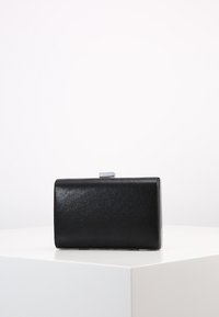 Czarna kopertówka z ekoskóry o prostokątnym kształcie, gładkiej fakturze i srebrnym zapięciu. Prosty design, minimalistyczny styl, bez widocznych wzorów.