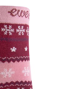Kniestrümpfe in Rosa und Burgunderrot mit Schneeflockenmustern. Stricktextur, gewellte Akzente und gesticktes Logo in der Nähe des oberen Randes.