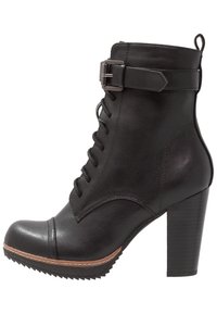 Botín negro con cordones, hecho de cuero texturizado, con un buckle lateral, punta redondeada y un tacón grueso con suela estriada.