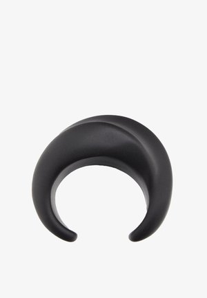 Jauge d'oreille en silicone noir incurvée, forme de croissant, surface lisse et extrémités effilées pour piercing de lobe d'oreille étiré.