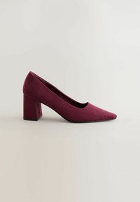 Zapato de tacón alto burdeos con puntera afilada y tacón cuadrado. Fabricado en un tejido suave y texturizado. Líneas suaves y diseño minimalista.